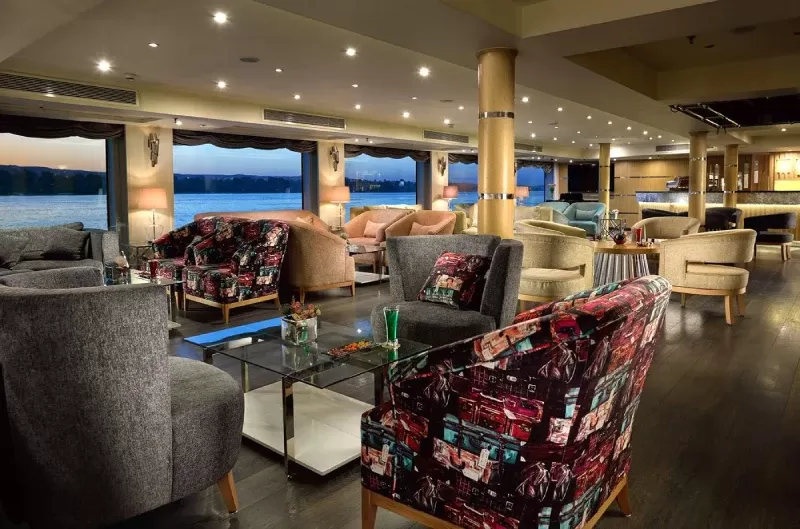 Luxurious cabin aboard MS Acamar Nile Cruise – plush bedding and panoramic window with Nile views