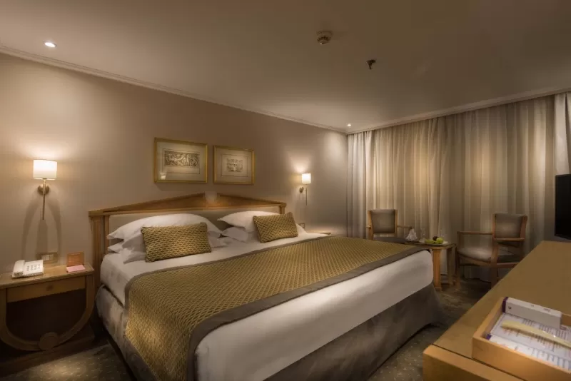 Luxurious cabin aboard Steigenberger Royale Nile Cruise – plush bedding and panoramic windows overlooking the river