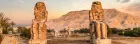 Colossi of Memnon in Luxor, Egypt, featuring two massive stone statues of Pharaoh Amenhotep III